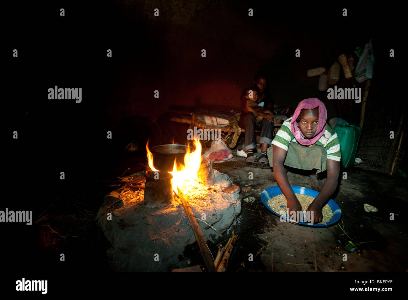 Woman preparing food suivant pour ouvrir le feu dans la hutte africaine Banque D'Images