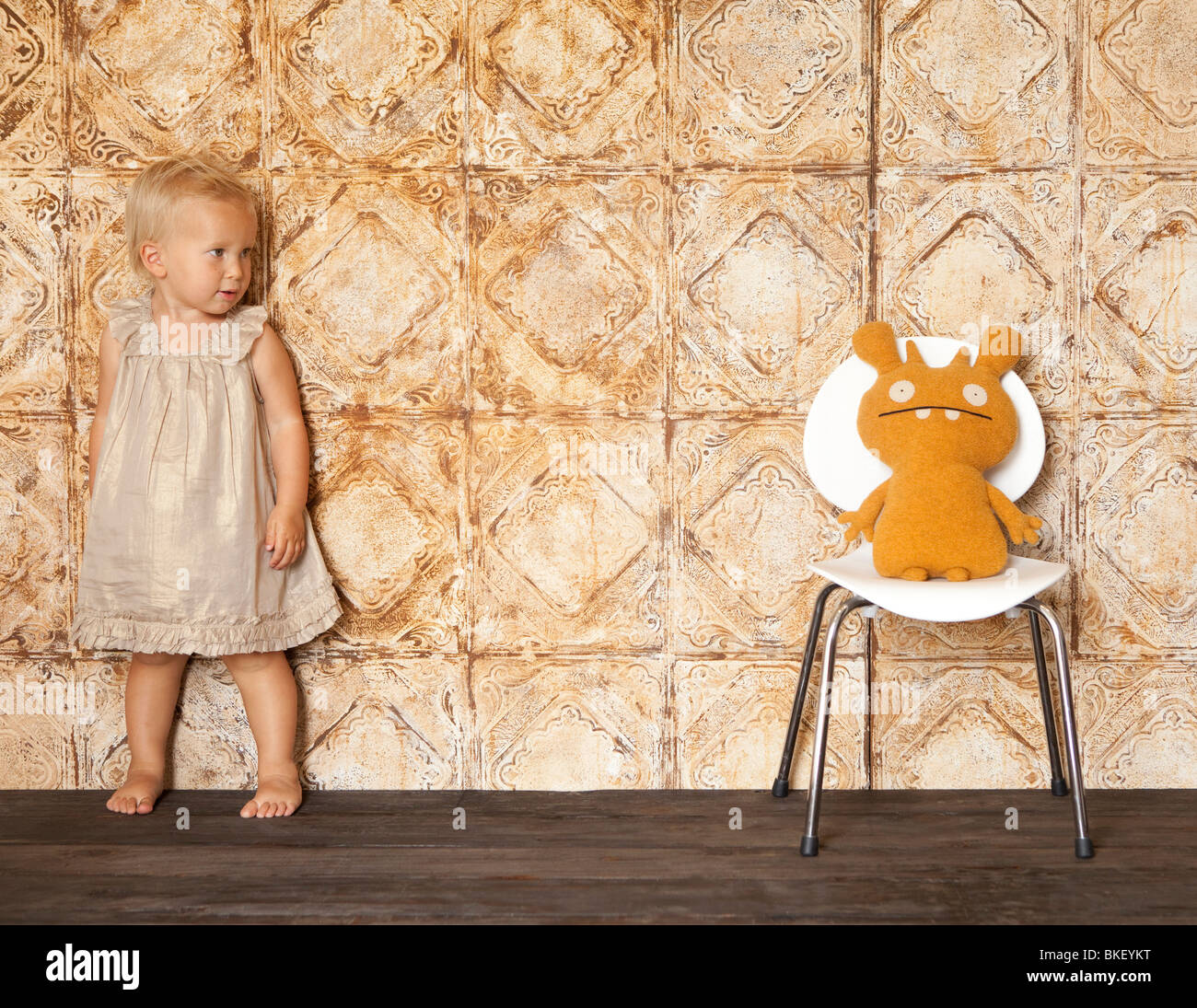 Petite fille peur d'animal en peluche sur une chaise Banque D'Images