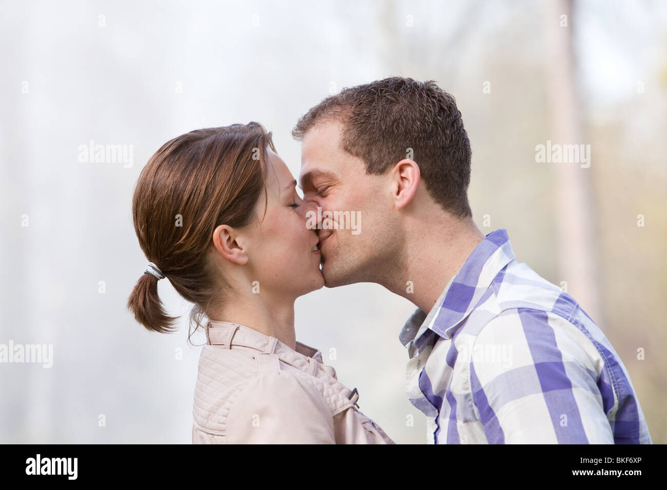 Beau jeune couple donnant l'autre un baiser Banque D'Images