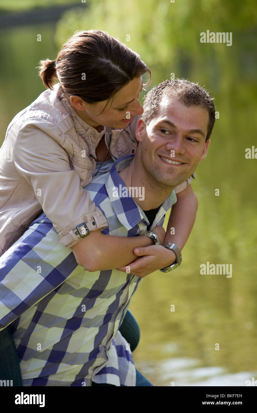 Beau jeune couple un piggyback ride dans le parc Banque D'Images