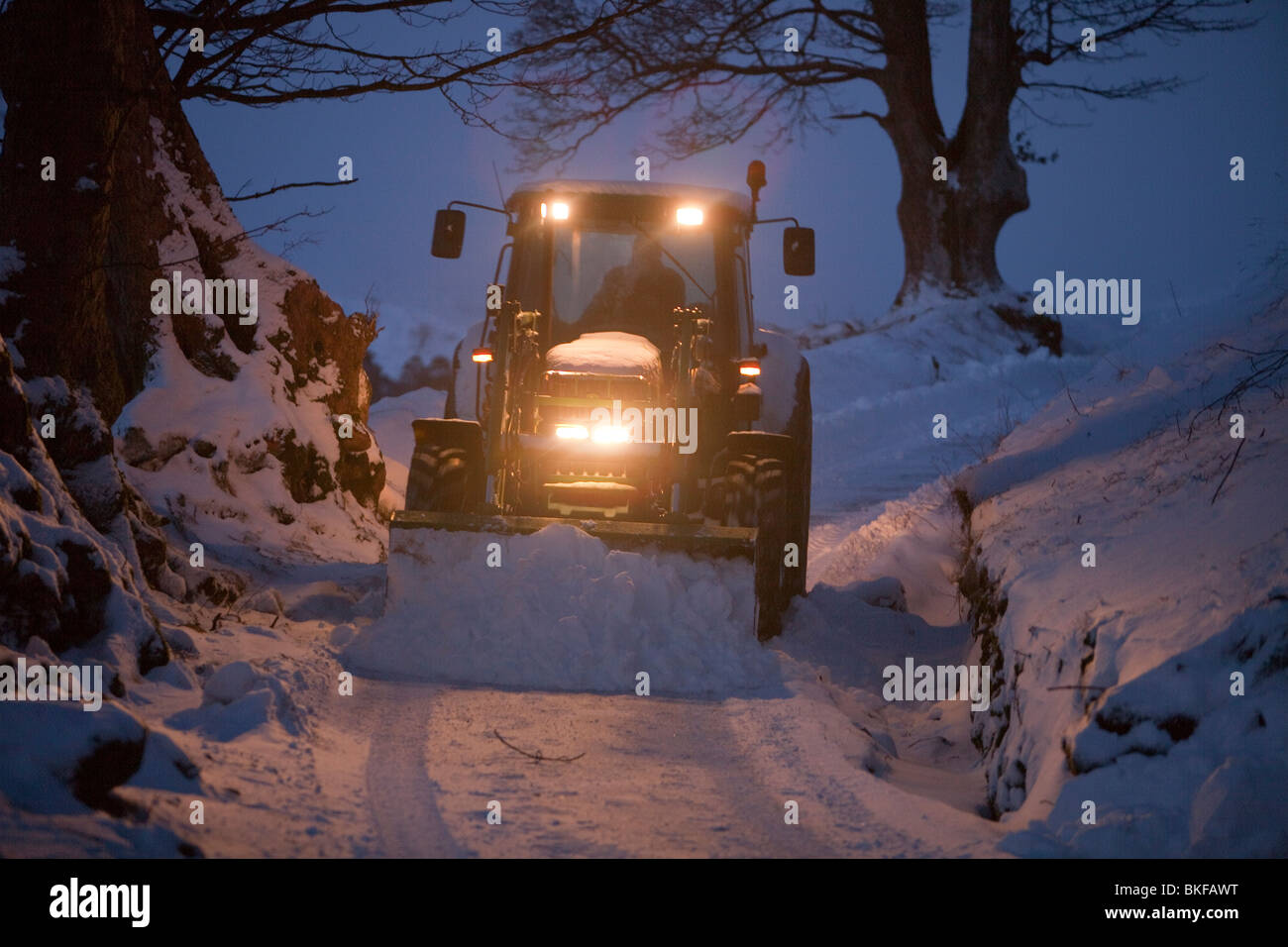 Un agriculteur déblayer la neige d'une lane près de Ambleside de neige, Lake District, UK. Banque D'Images