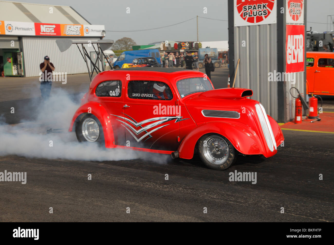 Outlaw Anglia faites glisser voiture conduite par Rob Stone, le réchauffant s pneus. Banque D'Images