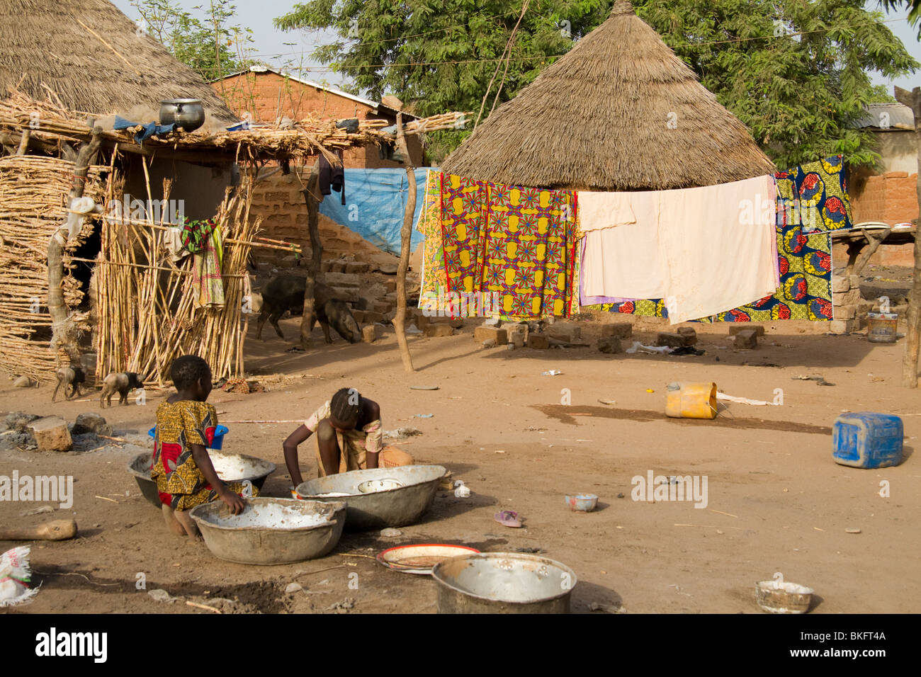 Des enfants nettoient des bols dans un village de la région de Garoua, Cameroun Banque D'Images