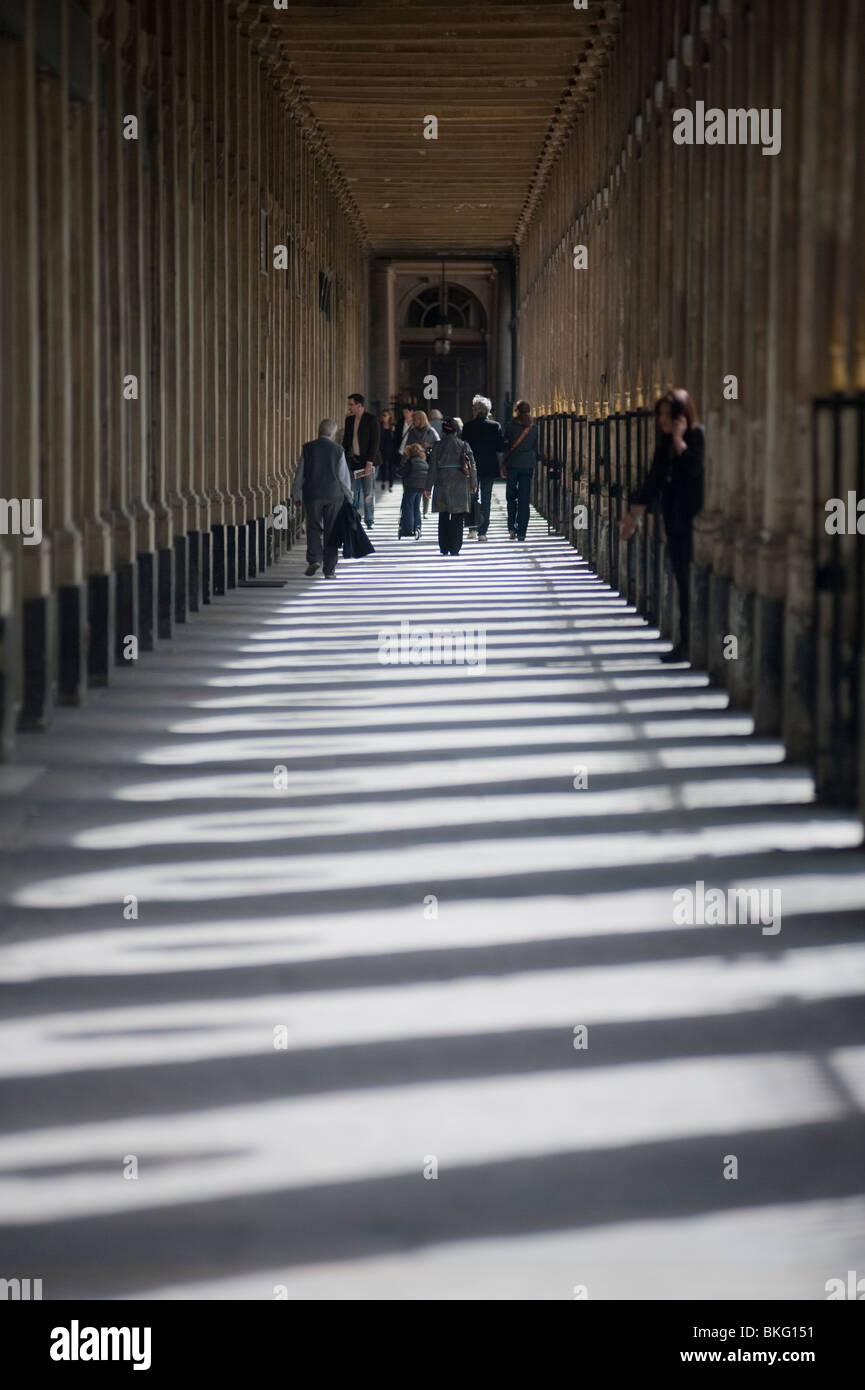 Personnes à pied, en profitant du parc urbain, jardin du Palais Royale, Printemps, Paris, France, Colonnade in Shadows,Rue historique et lumineuse de Paris Banque D'Images