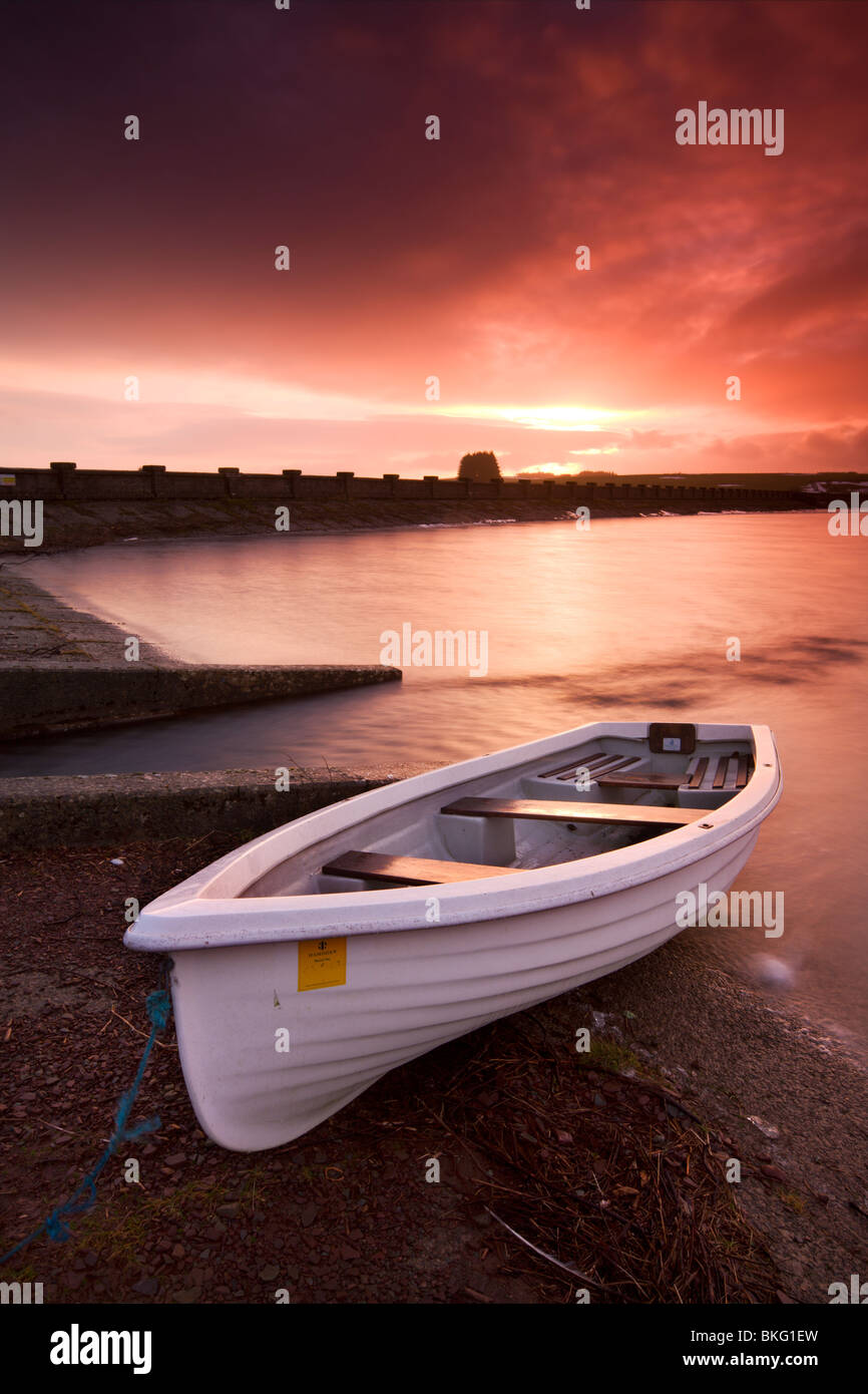 Bateau de pêche attachés sur les rives du réservoir d'Usk au lever du soleil, le Parc National des Brecon Beacons, Pays de Galles, Royaume-Uni. Banque D'Images