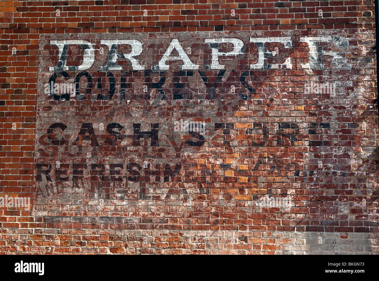 Témoignages sur un mur de vieux noms des commerçants et des entreprises dans un village anglais Banque D'Images