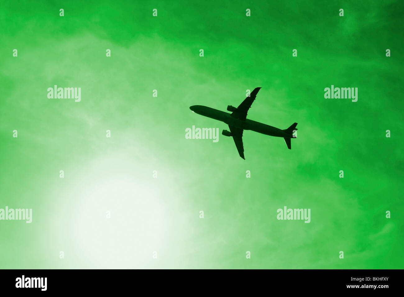 Avion près de sun contre ciel vert. Pourrait être utilisé pour représenter la pollution, les voyages aériens, empreinte carbone... Banque D'Images