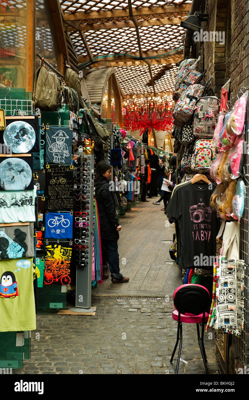 Un passage à travers les vêtements, tissu, matériaux et de souvenirs dans les étals de marché marché de Camden au nord de Londres Banque D'Images