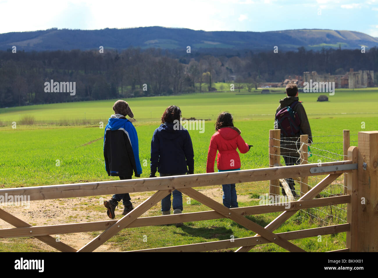 Groupe de marcheurs de la famille derrière cinq bar gate sur le champ en direction de Cowdray, Midhurst Banque D'Images