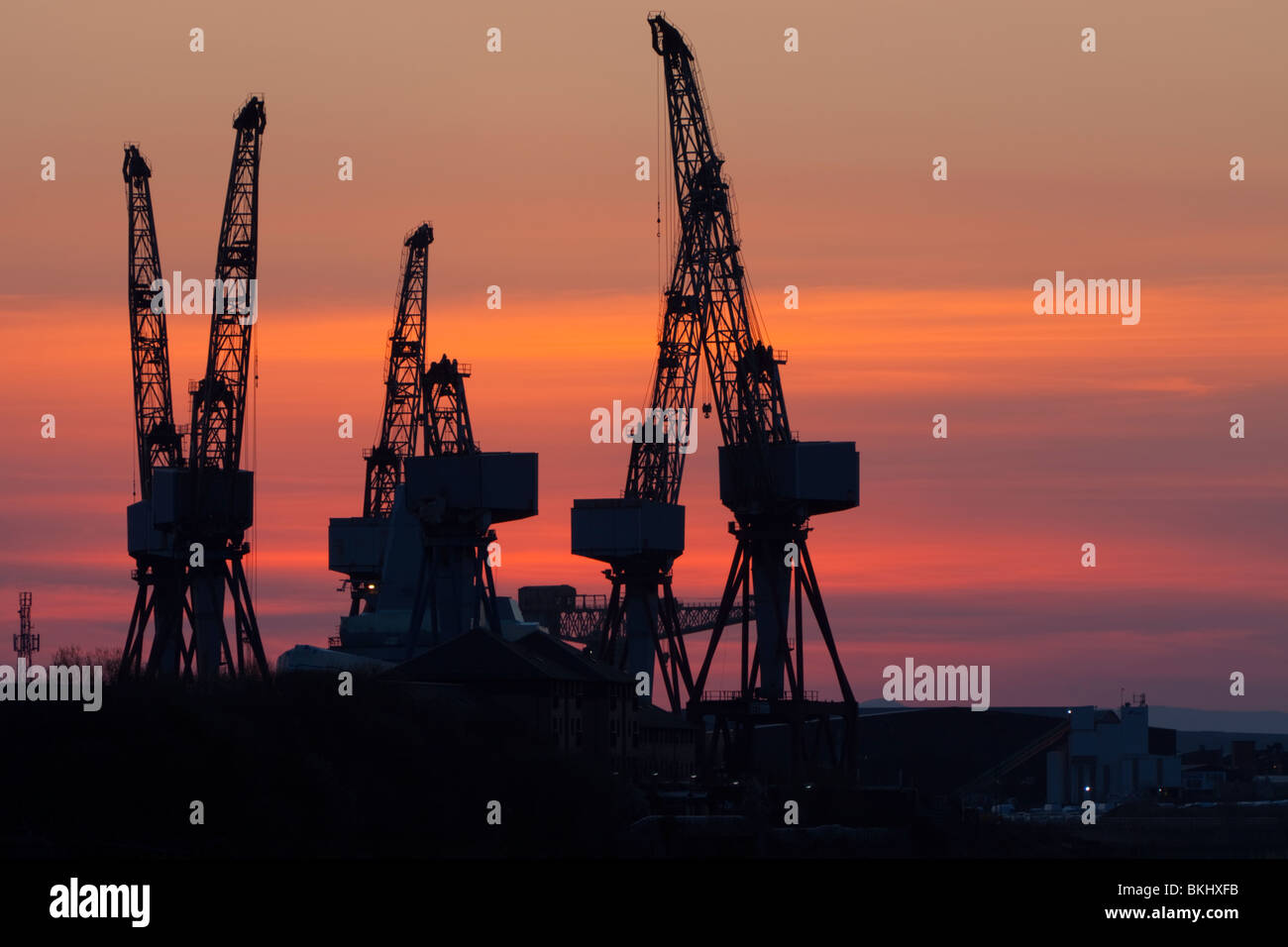 Grues du chantier naval de BAE Systems dans la région de Govan sur la rivière Clyde Glasgow au coucher du soleil Banque D'Images