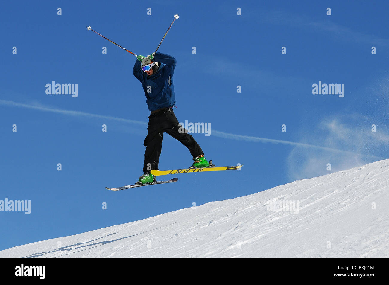 Un skieur s'envole un saut sur piste dans la station de ski de Courchevel, dans les Alpes françaises. Banque D'Images