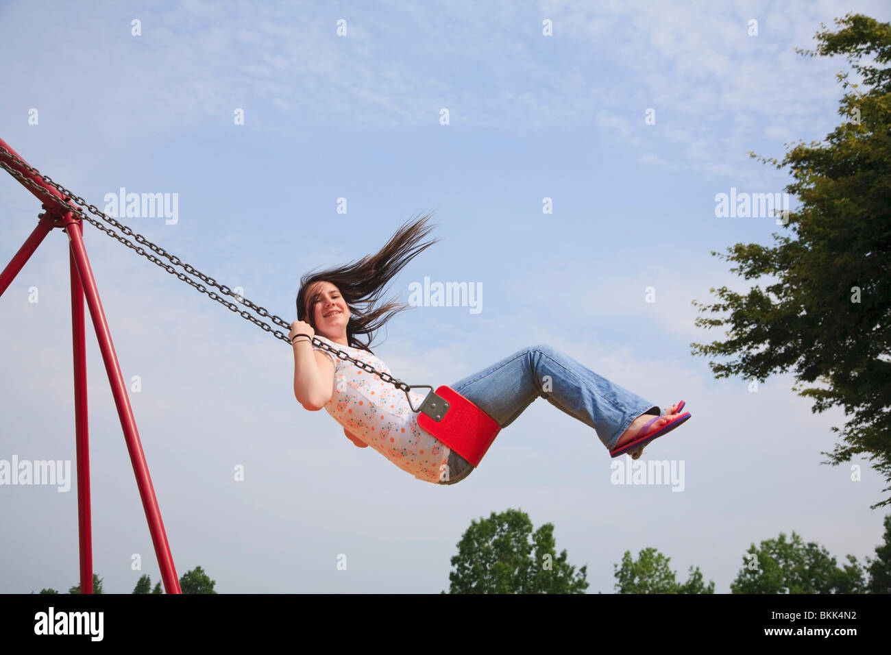 Une adolescente se balancer sur une balançoire Photo Stock - Alamy