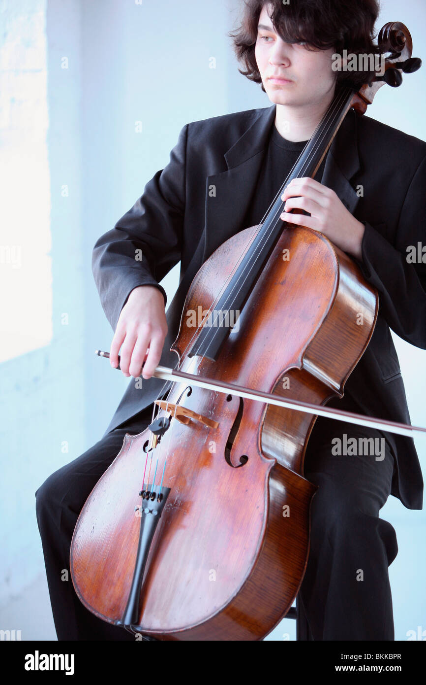 Un jeune homme jouant d'un violoncelle Banque D'Images