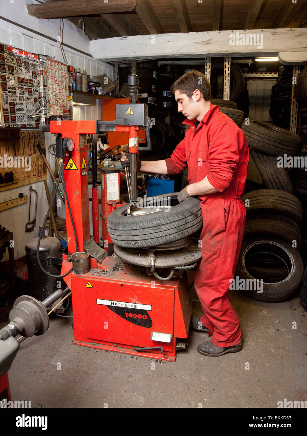 Un travailleur de garage changer un pneu sur une jante de roue de voiture Banque D'Images