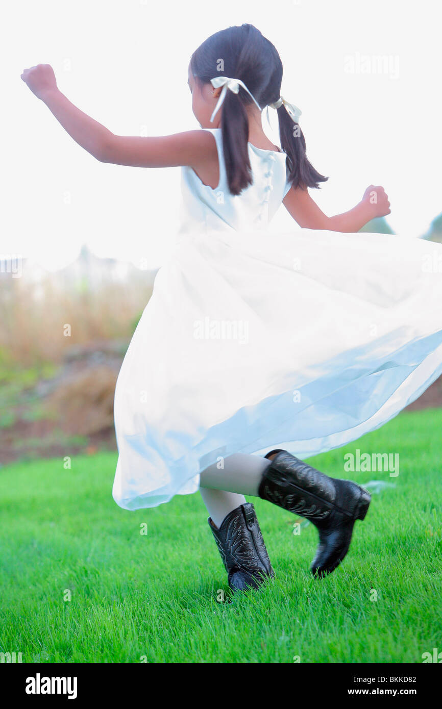Une jeune fille vêtue d'une robe blanche et des bottes de cow-boy Banque D'Images