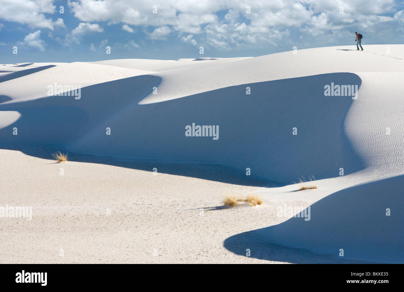 Une personne qui marche d'une grande dune de sable blanc au White Sands National Monument, Nouveau-Mexique. Banque D'Images