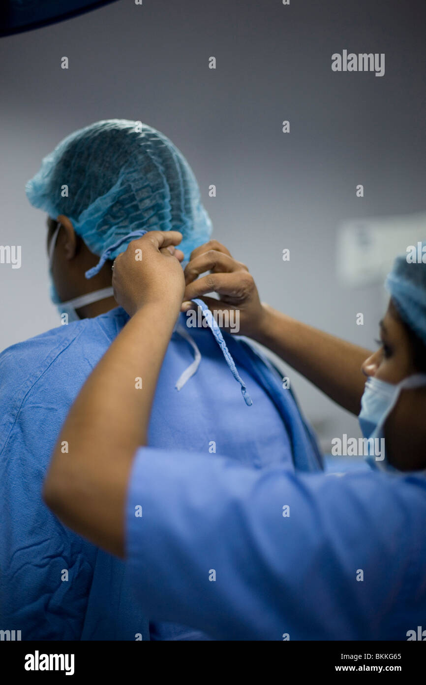 Un chirurgien a son masque lié par une infirmière avant qu'une opération dans l'Medicity, Gurgaon, Inde Banque D'Images