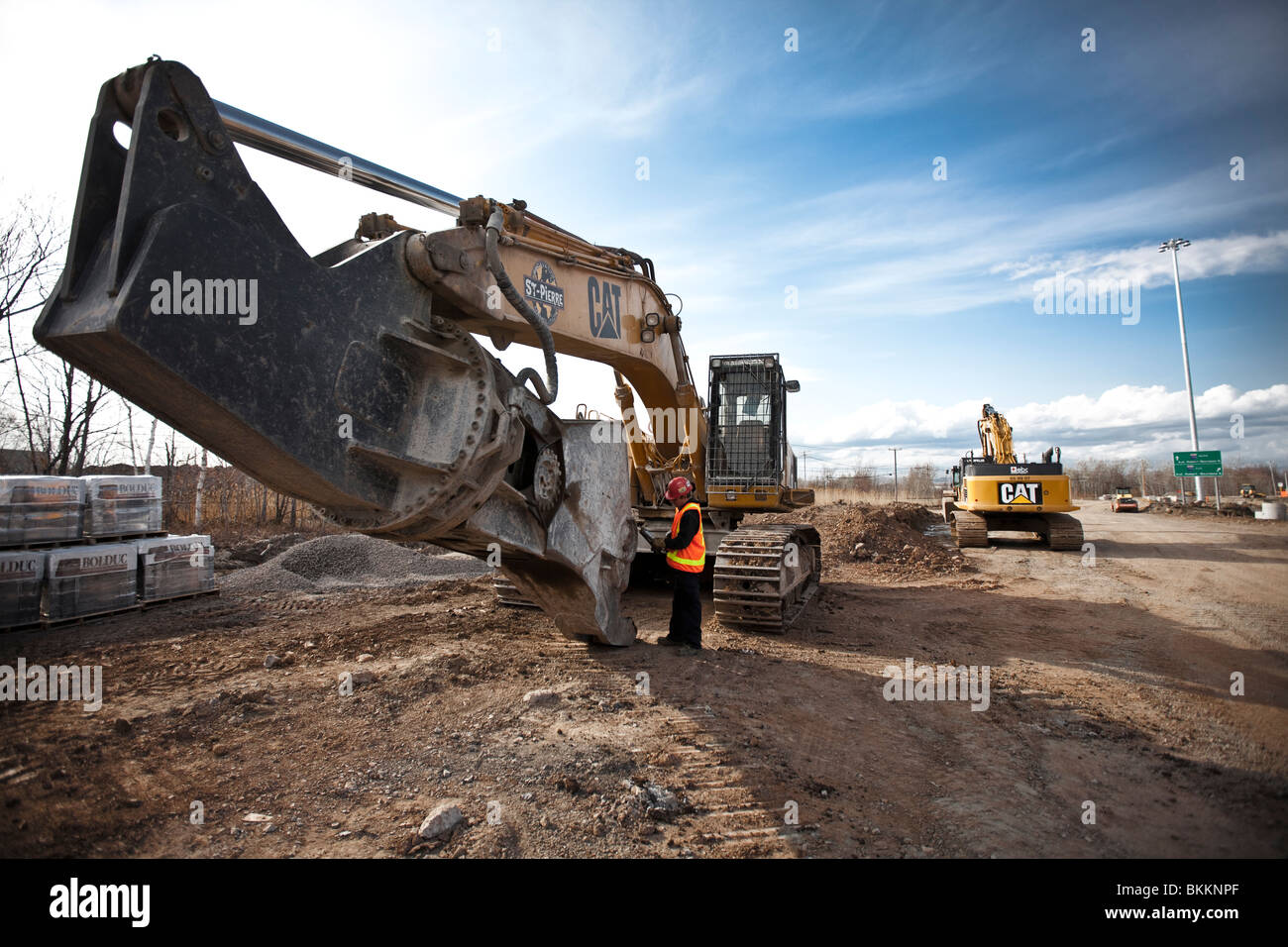 Les poids lourds de l'équipement de construction travaillent en équipe pour construire un projet routier au Québec. Banque D'Images