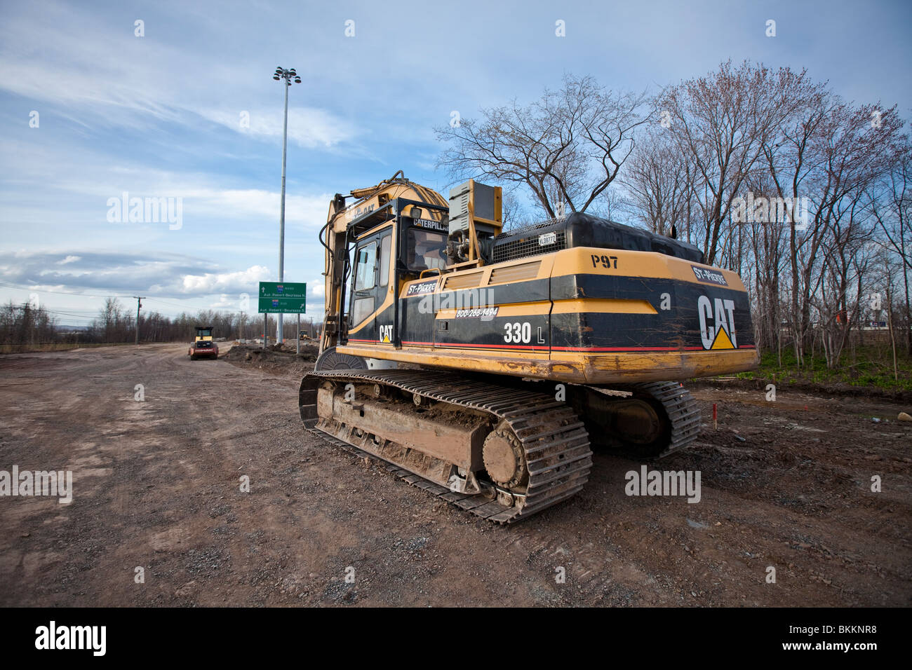 Les poids lourds de l'équipement de construction travaillent en équipe pour construire un projet routier au Québec. Banque D'Images