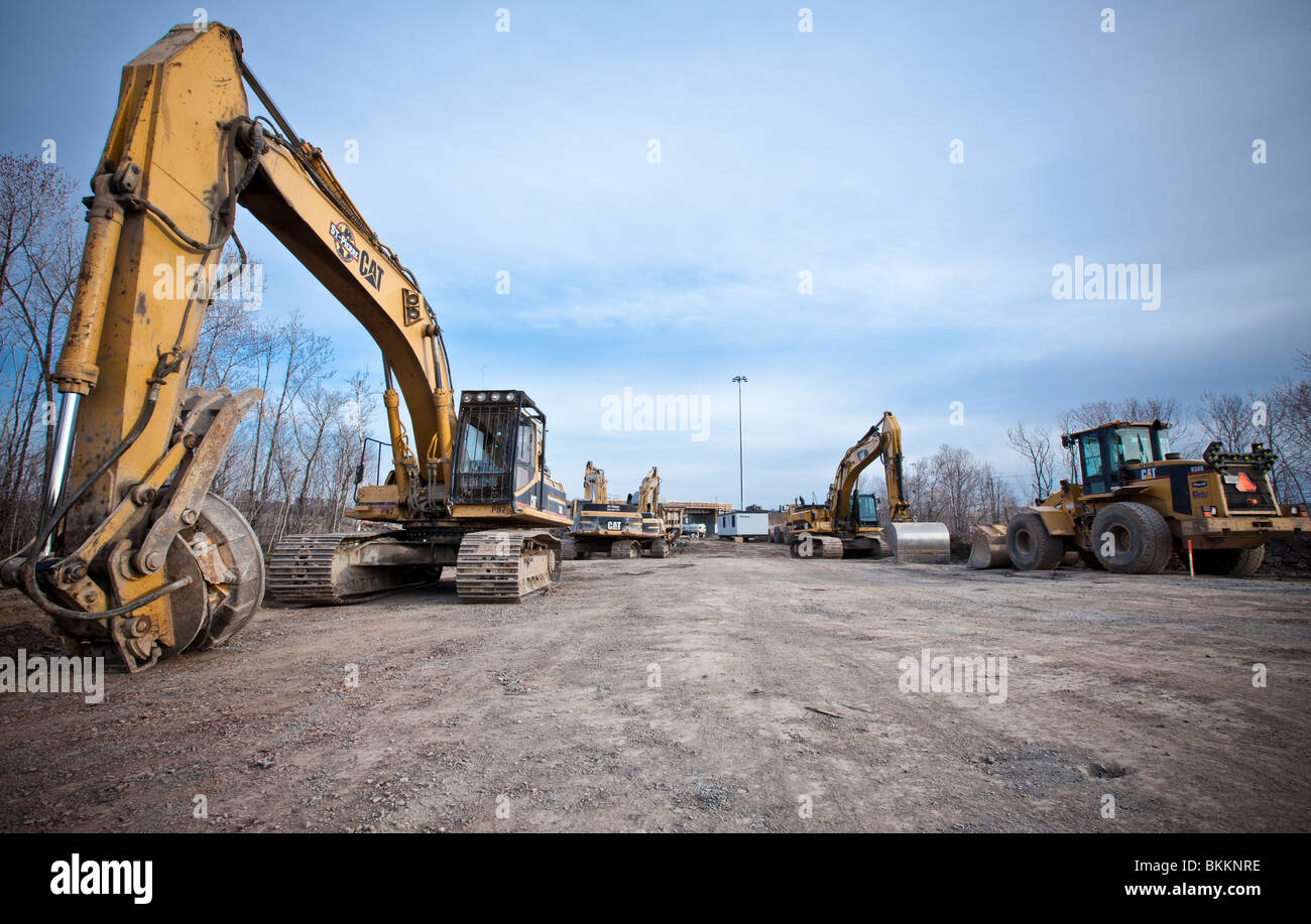Les poids lourds de l'équipement de construction travaillent en équipe pour construire un projet routier au Québec. Banque D'Images