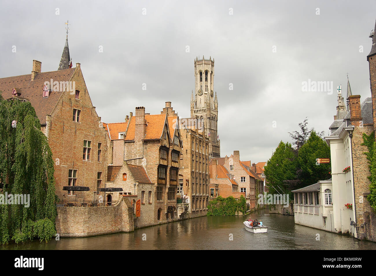 Un petit bateau passe par de beaux vieux bâtiments à Bruges, Belgique Banque D'Images