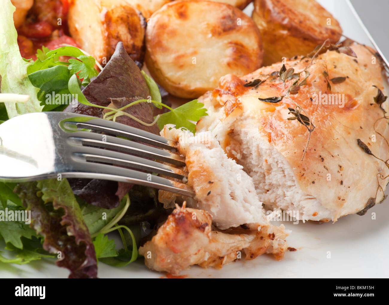 Poulet au romarin, avec pommes de terre rôties et salade Banque D'Images