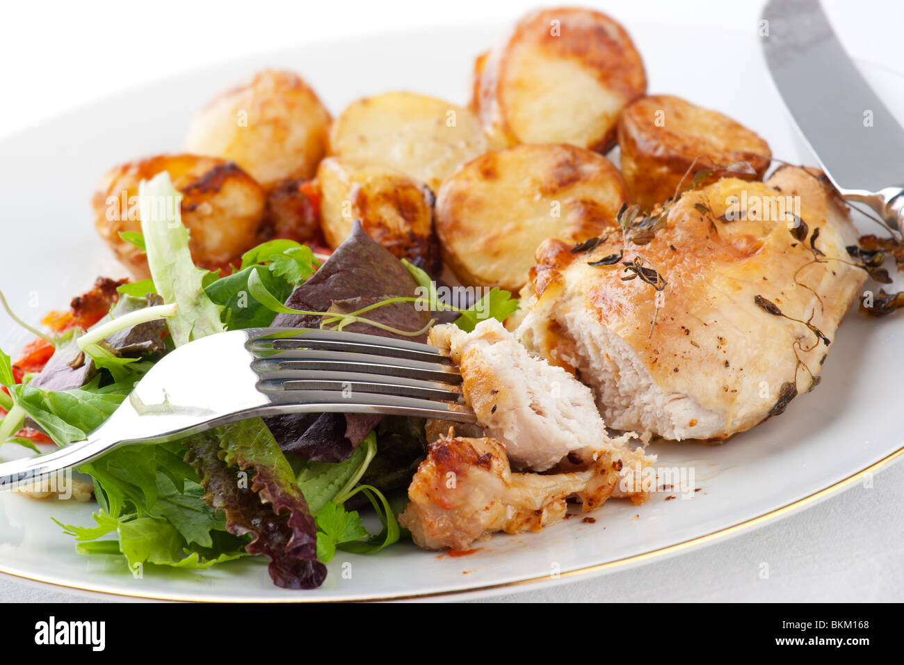 Poulet au romarin, avec pommes de terre rôties et salade Banque D'Images