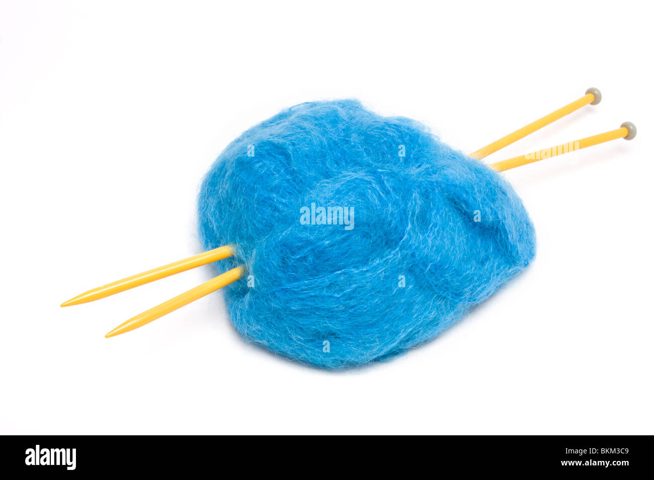 Une grande balle de laine mohair bleu percé avec de grandes aiguilles à tricoter en plastique jaune contre blanc. Banque D'Images