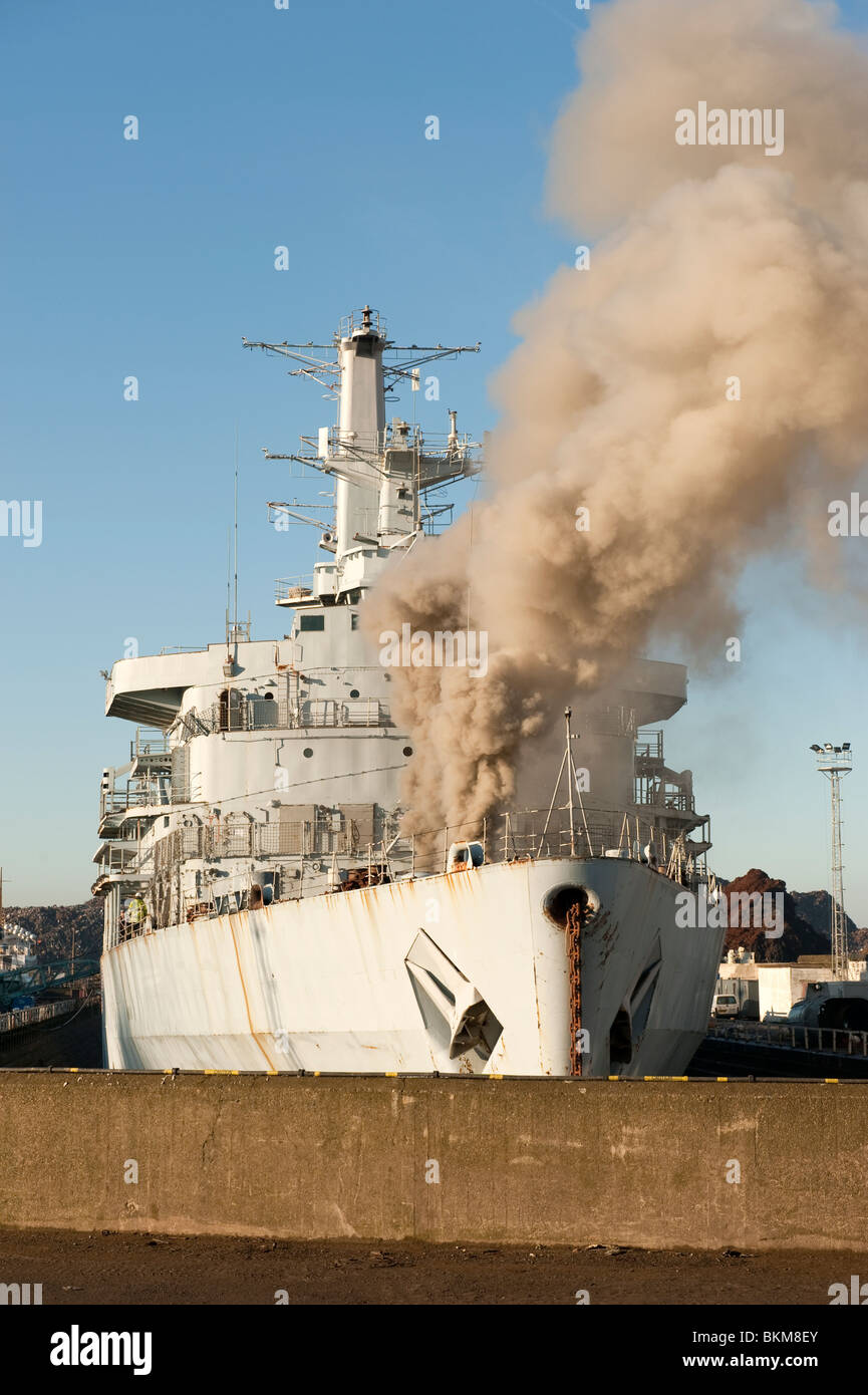 Ex Bateau de la marine américaine en feu dans le dock avec de grandes quantités de fumée à tenir Banque D'Images