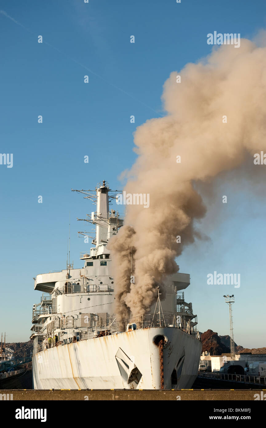Ex Bateau de la marine américaine en feu dans le dock avec de grandes quantités de fumée à tenir Banque D'Images
