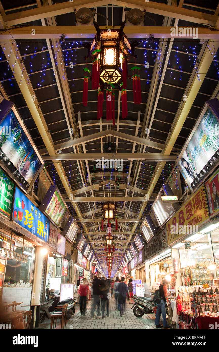 Les panneaux d'éclairage sans fin et les gens la nuit shopping dans la rue du Marché de nuit de Huaxi touristiques, Wanhua District, Taipei, Taiwan Banque D'Images