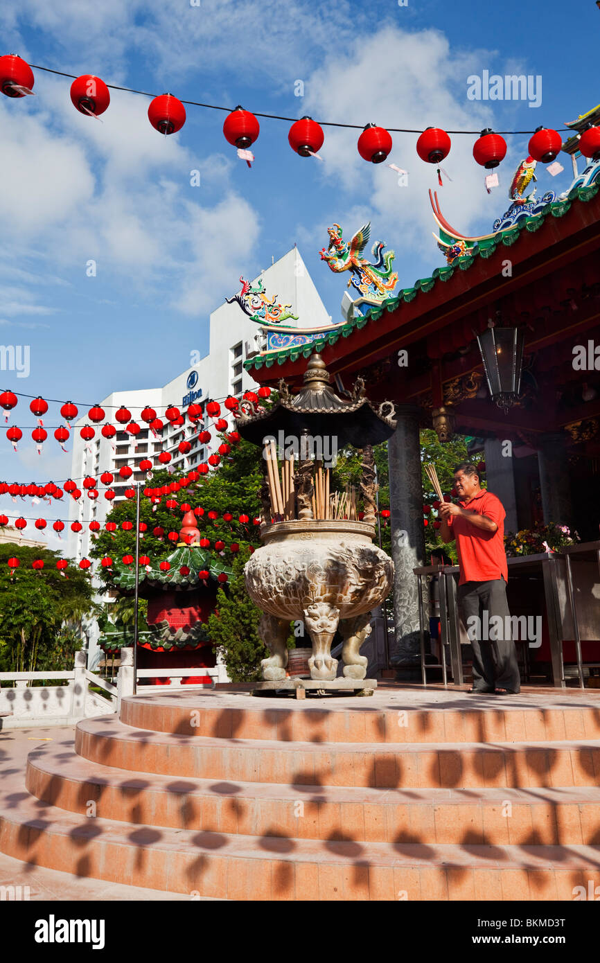 Un dévot fait une offrande de l'encens au temple chinois de Tua Pek Kong. Kuching, Sarawak, Bornéo, Malaisie. Banque D'Images