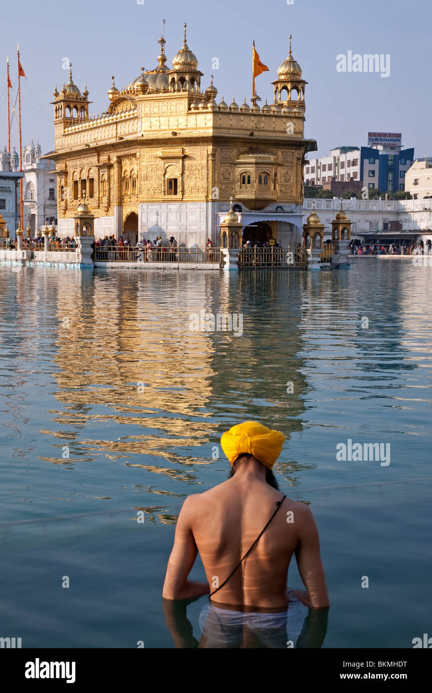 Homme Sikh de prendre le bain rituel dans le Temple d'or Bassin sacré (l'Amrit Sarovar). Amritsar. Punjab. L'Inde Banque D'Images