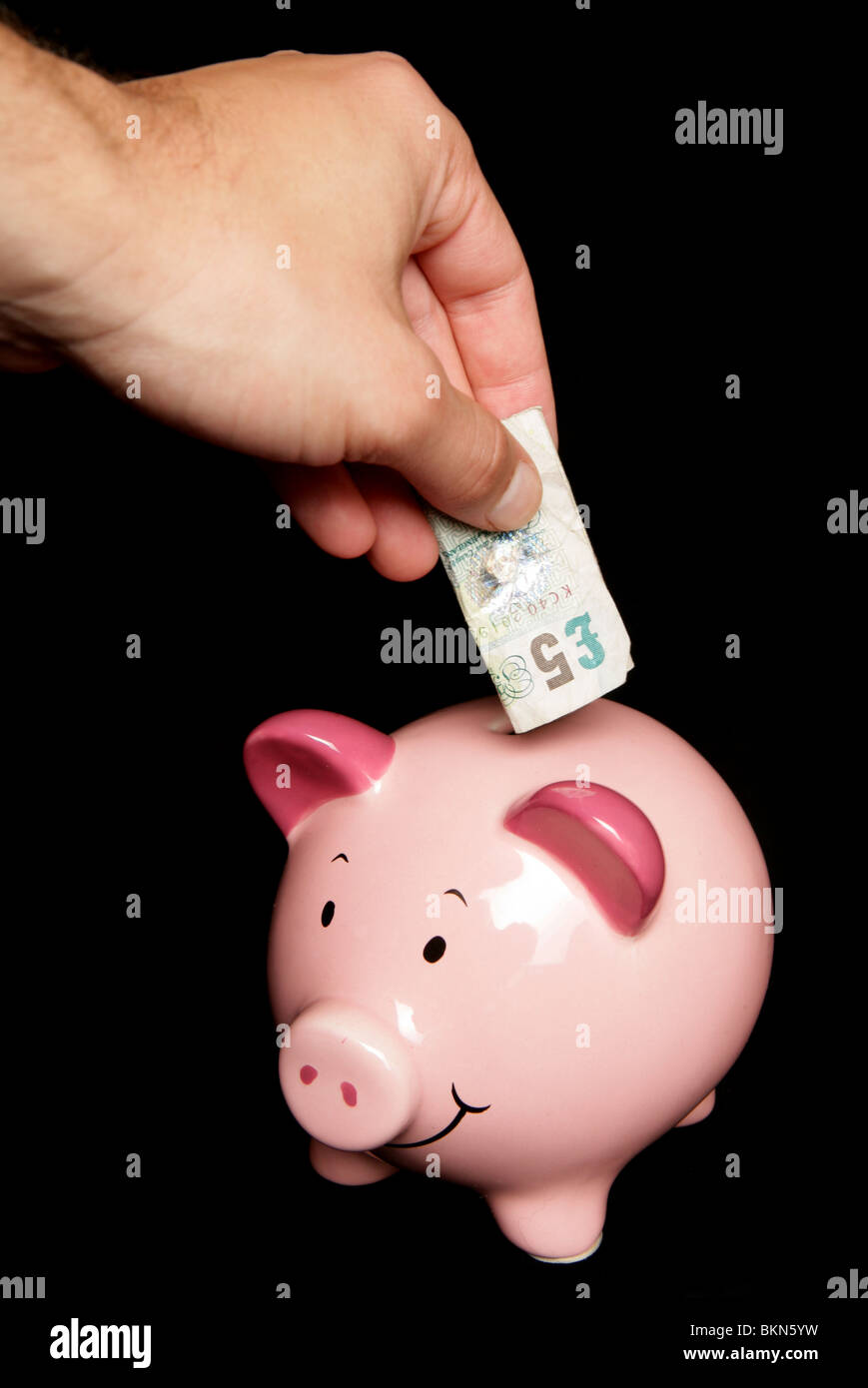 Personne d'économiser de l'argent dans la tirelire Banque D'Images