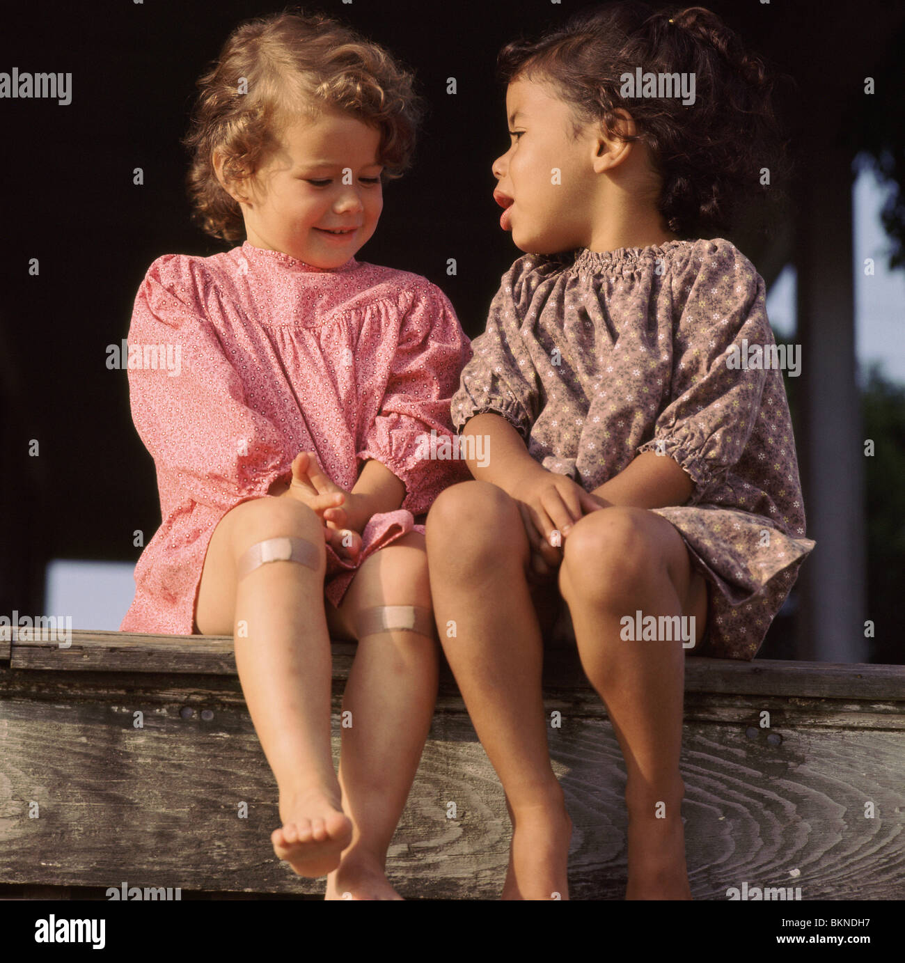 Close-up de deux petites filles de parler tout en étant assis sur une étape Banque D'Images