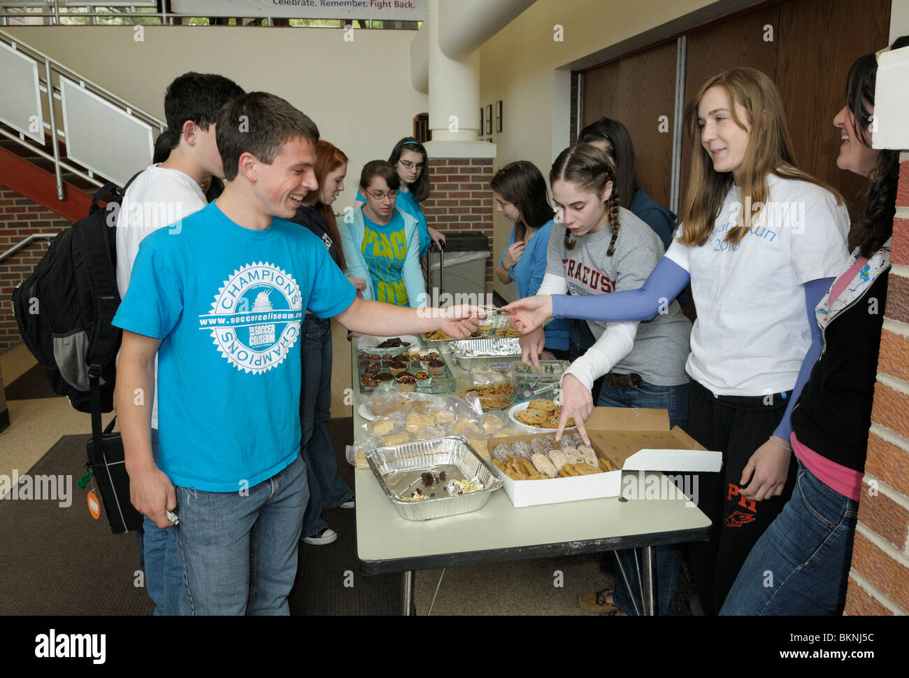 Les élèves du secondaire à la collecte d'une vente de pâtisseries après l'école de collecte de fonds. Banque D'Images