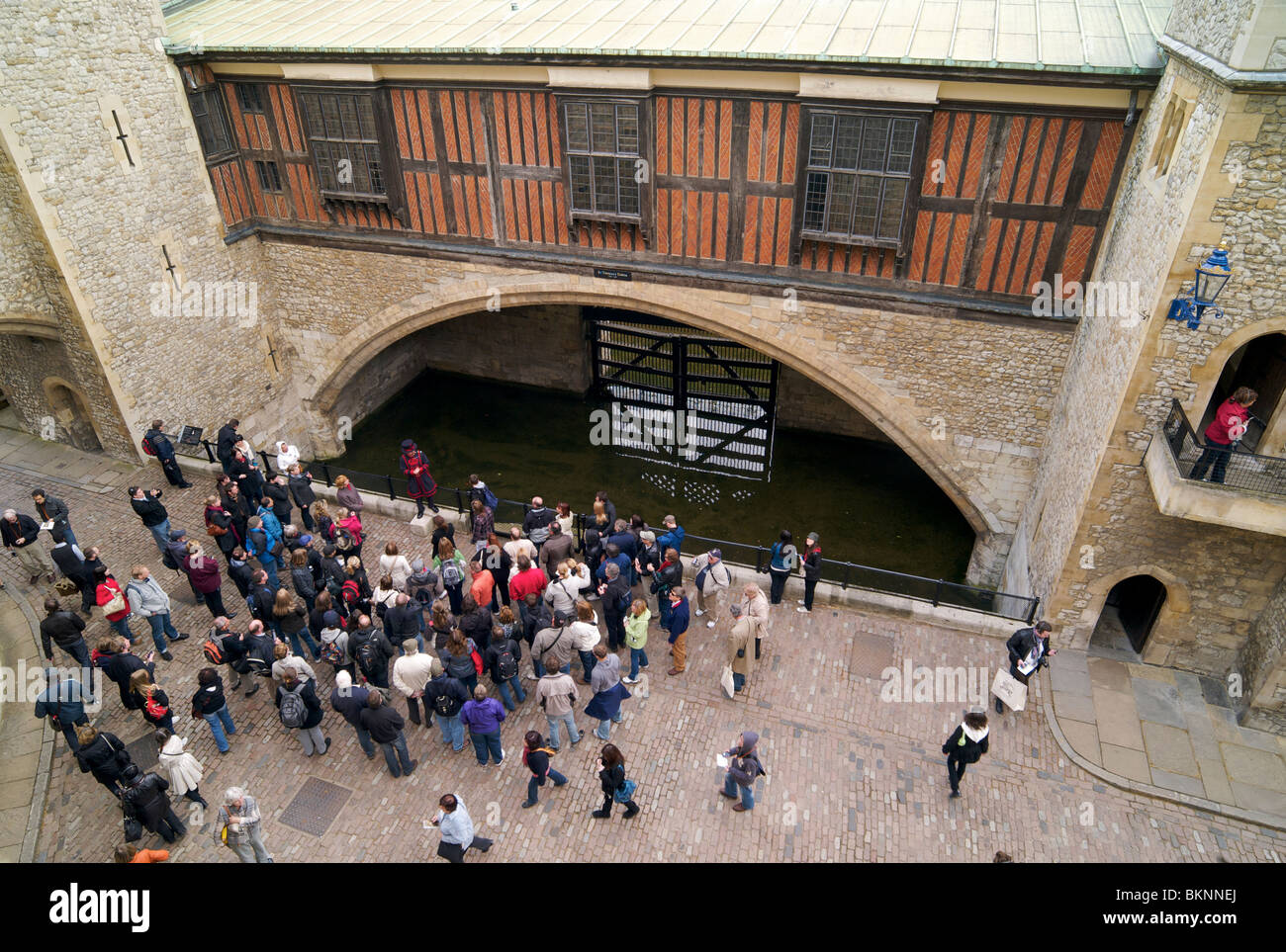 Un Yeoman warder Beefeater ou guider les touristes près de traître's Gate dans la Tour de Londres Banque D'Images