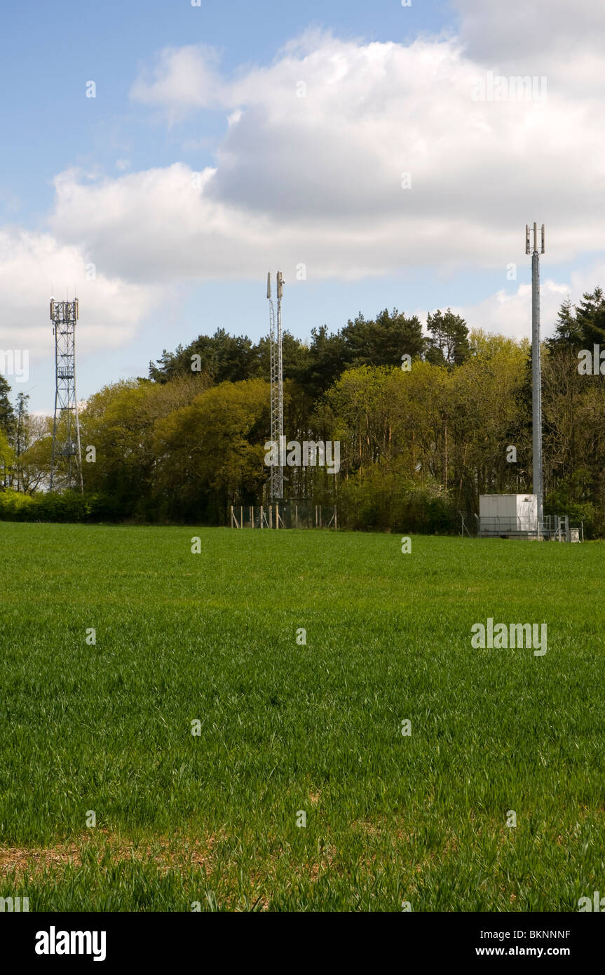 Toi mâts de téléphonie mobile sur les terres agricoles dans la région des Cotswolds, à la verticale. Banque D'Images