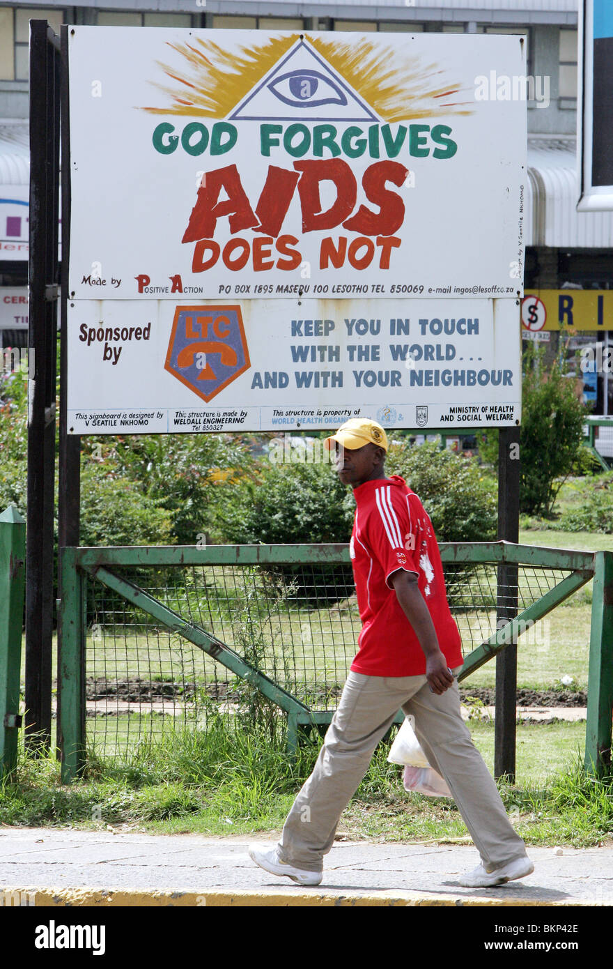 Un homme passe d'un contrôle routier hoaring avertissement des dangers du VIH/sida. Maseru, capitale du Lesotho Banque D'Images
