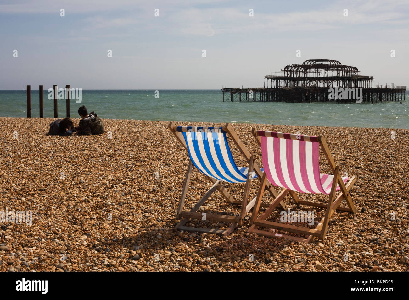 Brighton plage transats et ruiné West Pier. Banque D'Images
