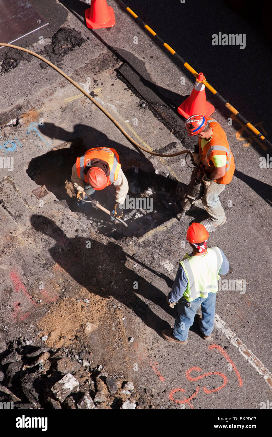 Les travailleurs de la construction déterrer un street pour la réparation. Banque D'Images