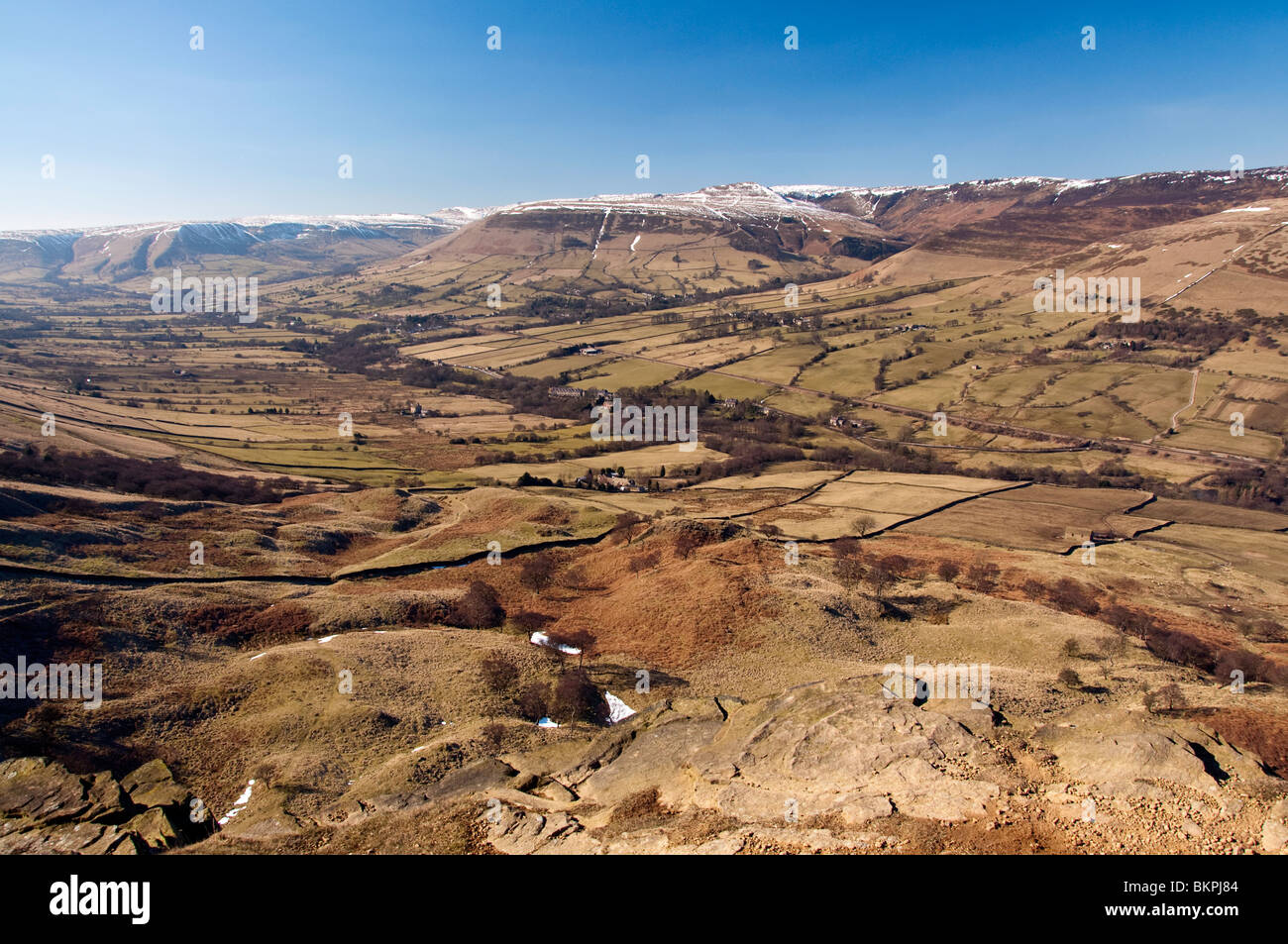 La neige recouvre les sommets des collines environnantes, tandis que le Vale d'Edale dans le Peak District bénéficie d'un soleil d'hiver. Banque D'Images