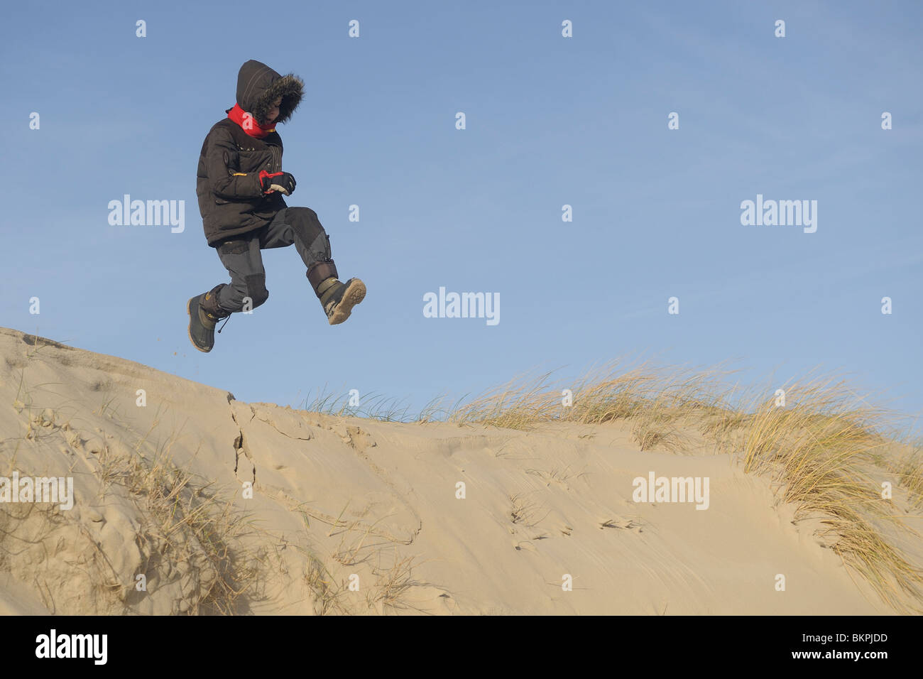 Een Jongen springt van duintop, garçon saute d'une dune Banque D'Images