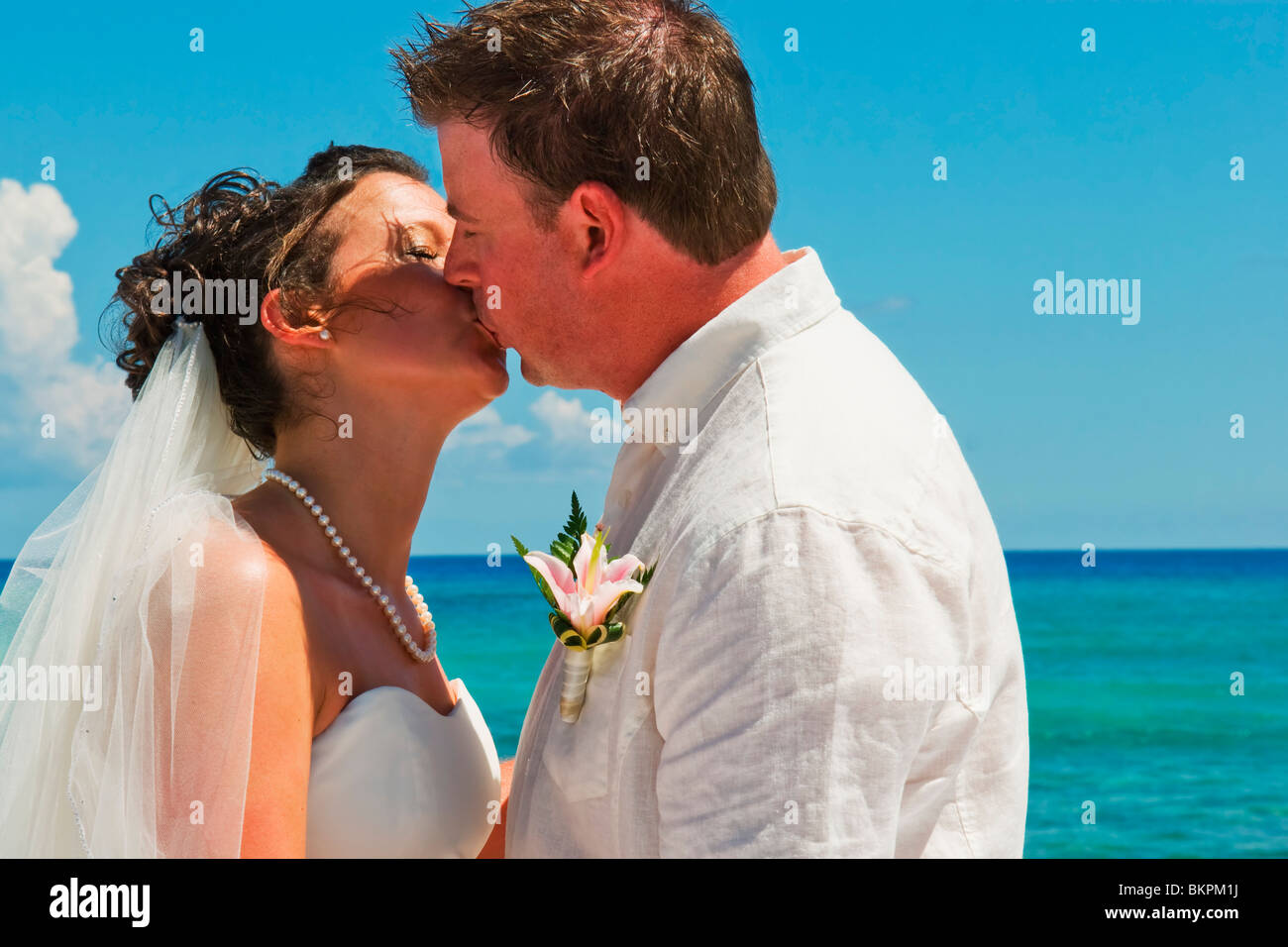 Akumal, Riviera Maya, Mexique ; une mariée et le Marié baiser sur la plage de Gran Bahia Principe Tulum All-Inclusive Resort Banque D'Images