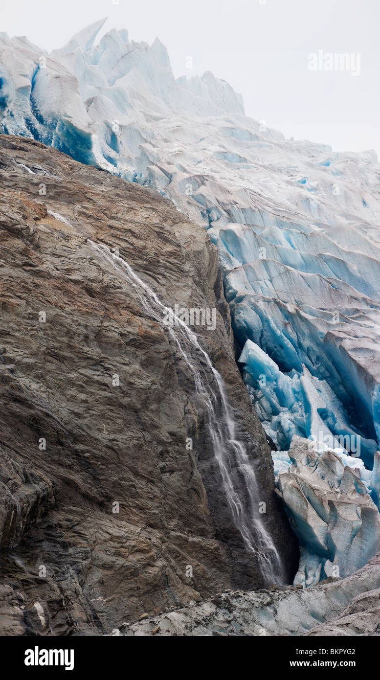 Une cascade s'écoule sur la roche a révélé récemment le bord ouest du glacier de Mendenhall, Juneau, AK. L'été. Panorama composite Banque D'Images