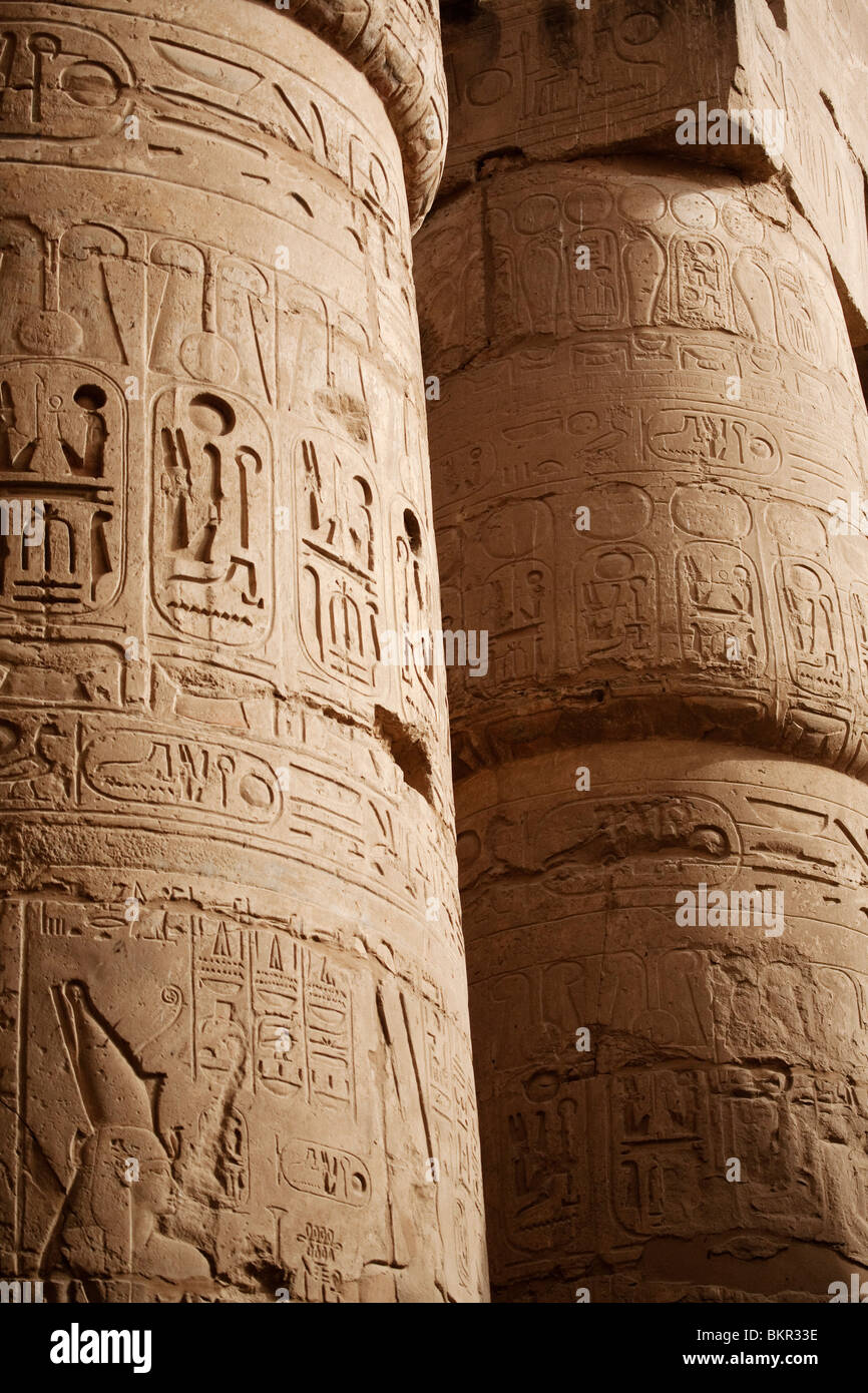 Egypte, Karnak. Les hiéroglyphes ornent les côtés de la colonnes massives dans la salle hypostyle de Karnak. Banque D'Images