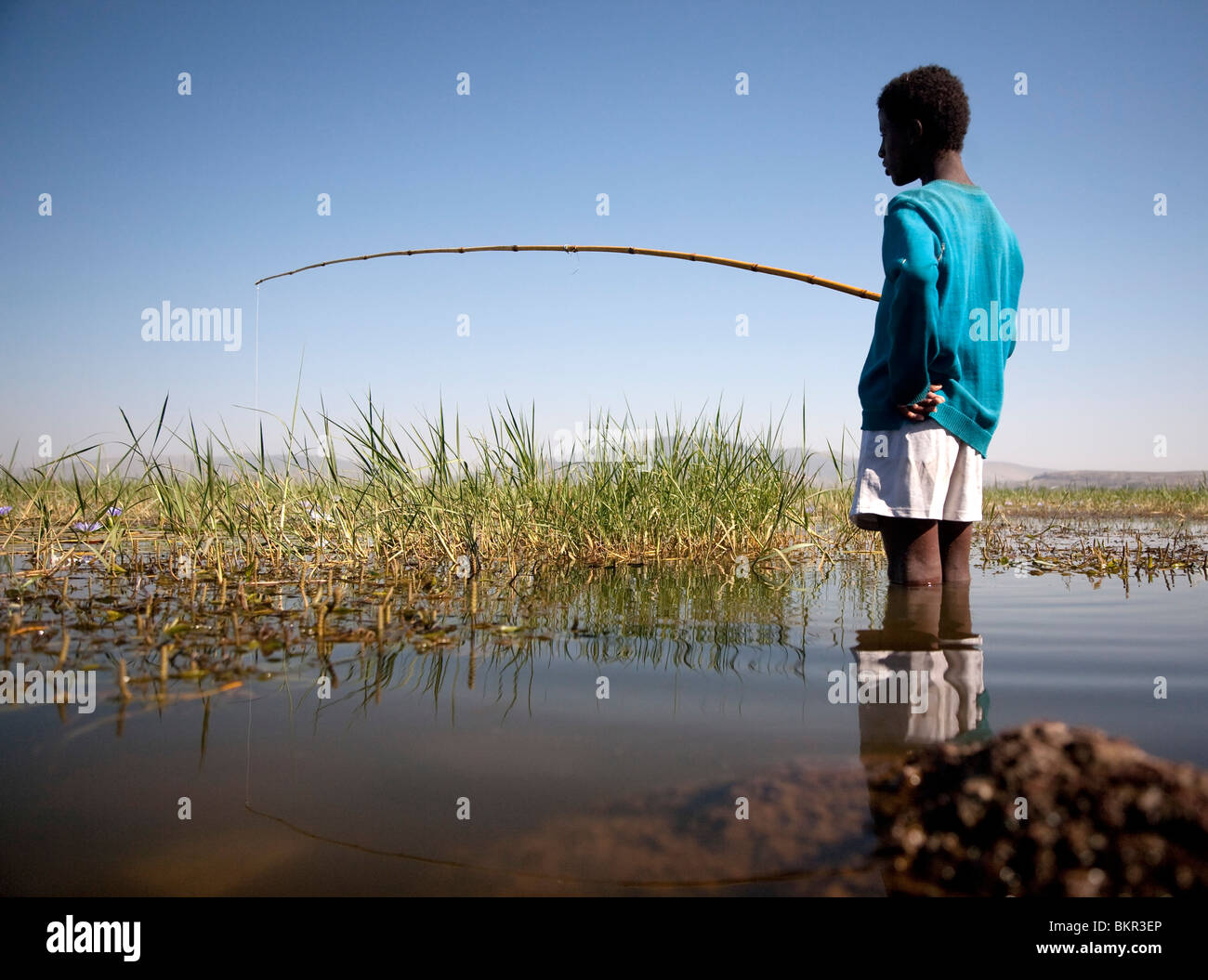 L'Éthiopie, le lac Awassa. Un jeune garçon poissons avec une canne à pêche en bambou. Banque D'Images