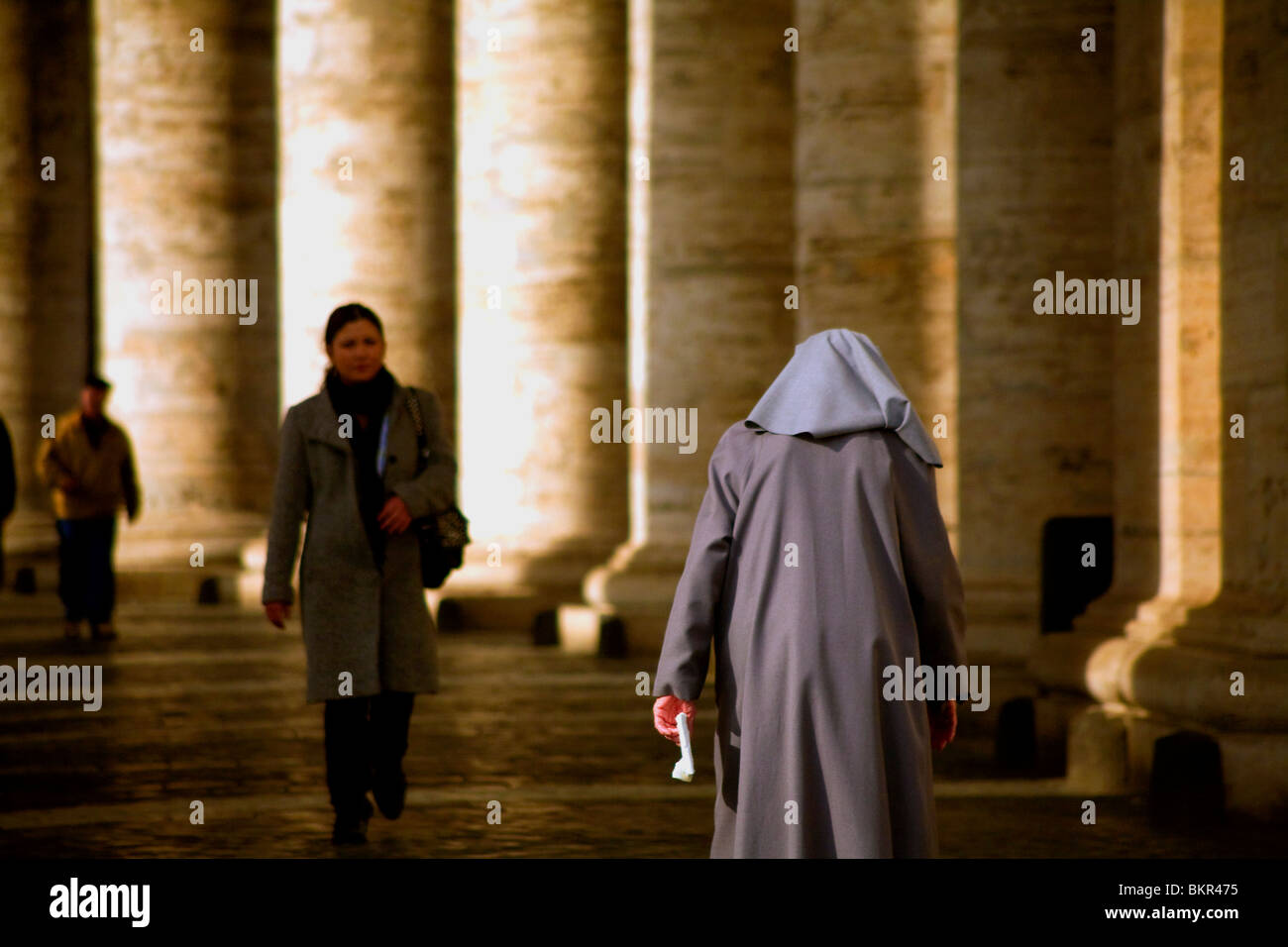 Italie, Rome ; une religieuse de marcher sous l'arche le long de la Piazza San Pietro Banque D'Images