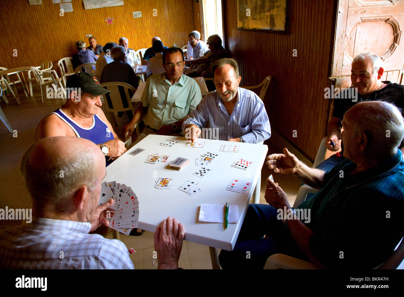 L'Italie du Sud, Sicile, Pozzallo. Hommes retraités tuer le temps par des cartes à jouer dans un club. Banque D'Images