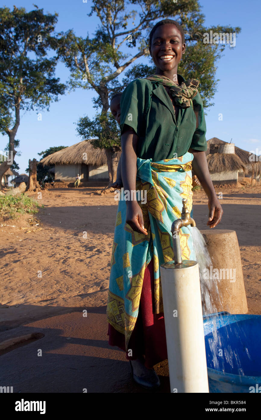 Le Malawi, Lilongwe, Ntchisi réserve forestière. Avec un approvisionnement en eau propre les villageois se réunissent pour recueillir de l'eau Banque D'Images